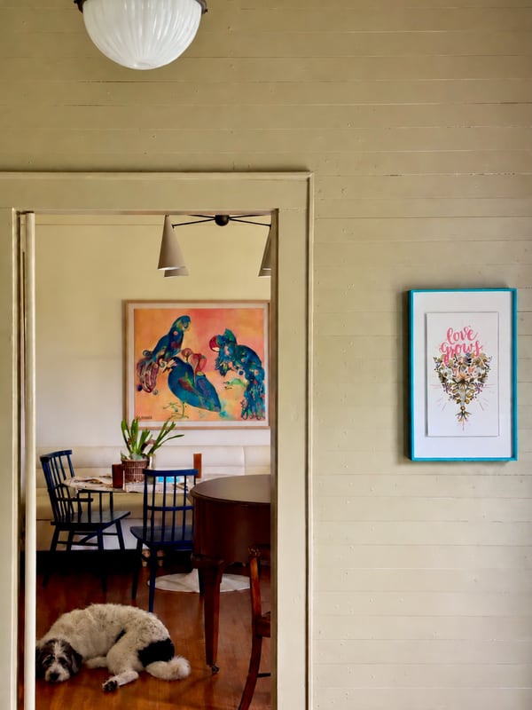 A view through an open doorway into the dining room, where a dog sleeps on the wood floor.