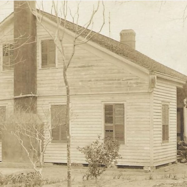 A sepia photograph of the Fox House in the 1800s, with the family on the porch.